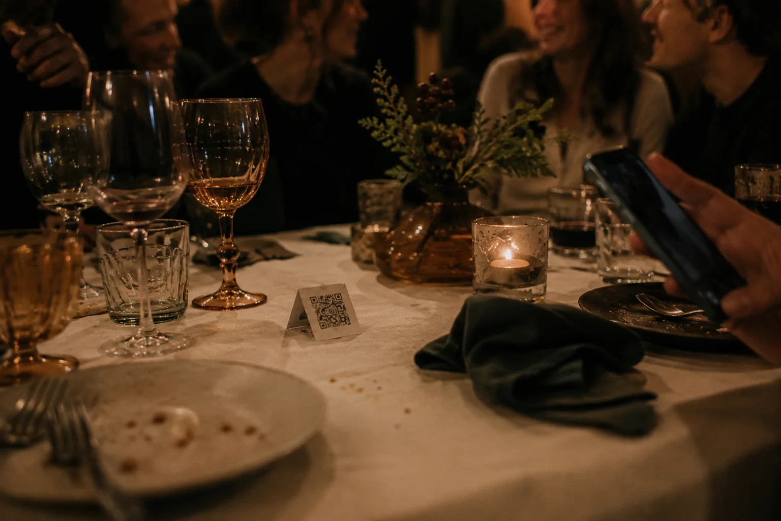 Une carte QR Flaash posée sur une table de soirée pendant qu'un invité la scanne.